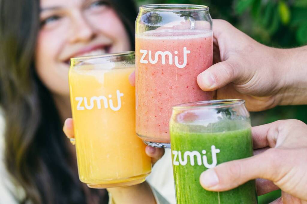 Smoothies Zumit com a tecnologia IQF nas mãos de pessoas sorridentes