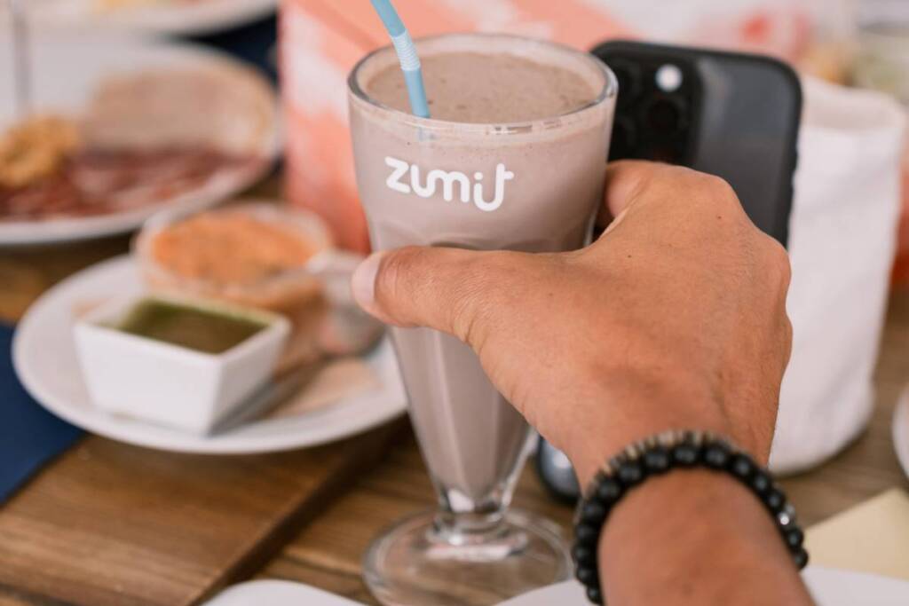 Milkshake Zumit Puro Chocolate, com gelado de chocolate e baunilha numa mão
