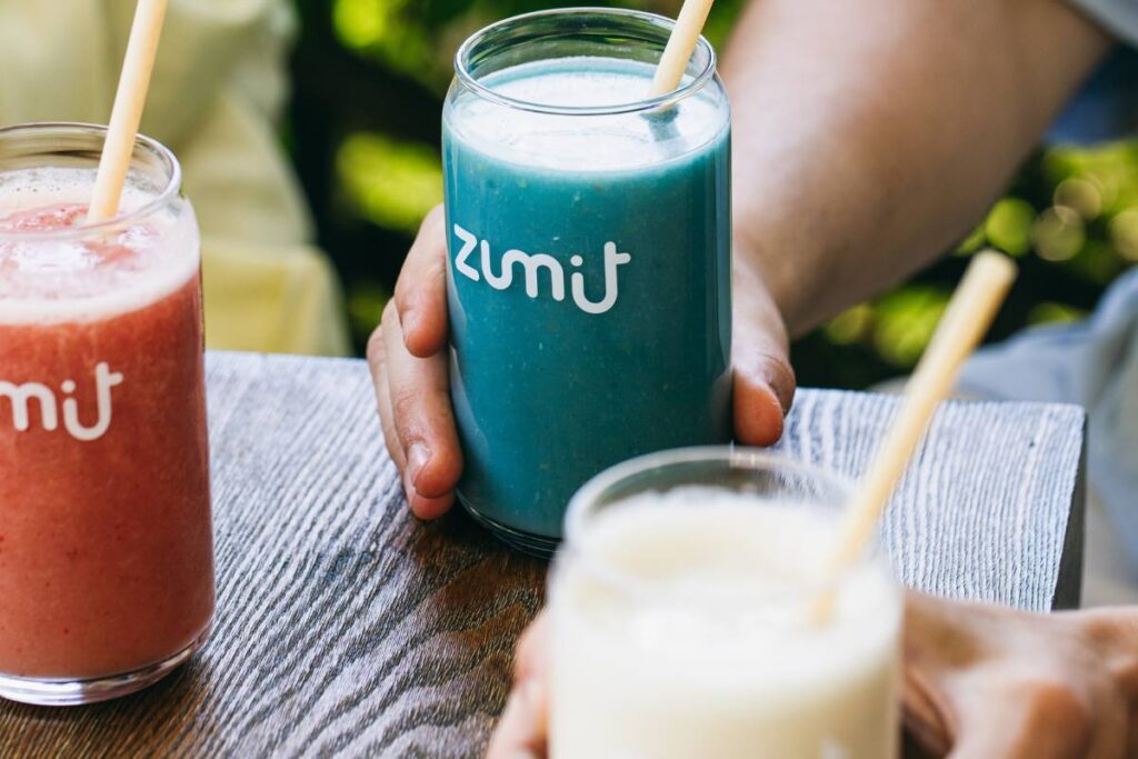Smoothies para Horeca Zumit Blue Lightning com manga, banana, ananás, pêssego, coco e espirulina azul sobre uma mesa