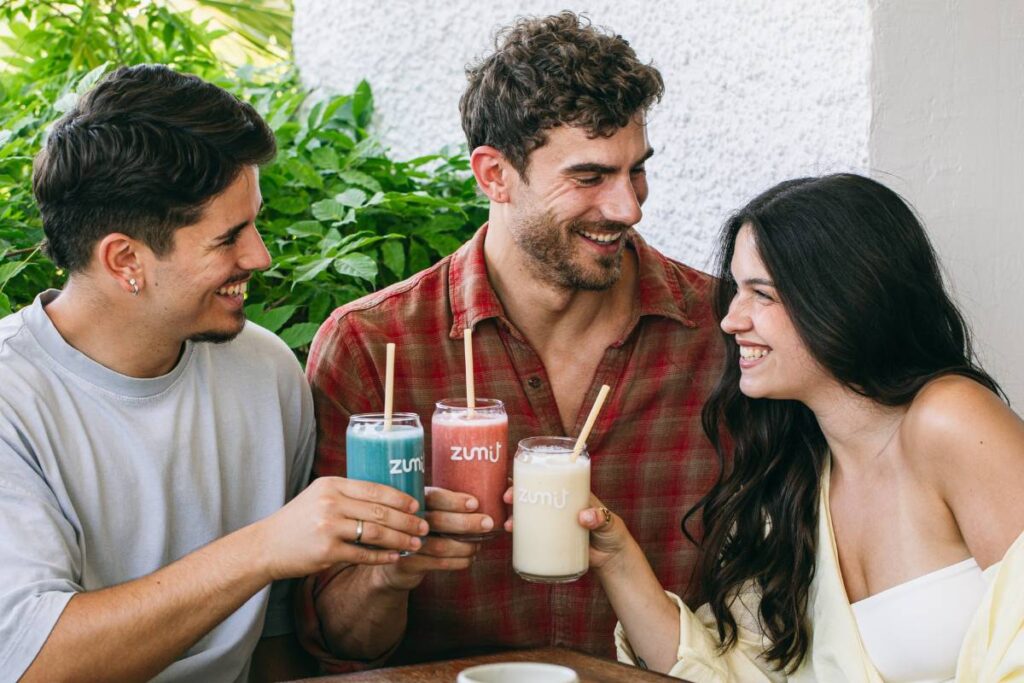 Smoothies Zumit nas mãos de algumas pessoas enquanto conversam entre si
