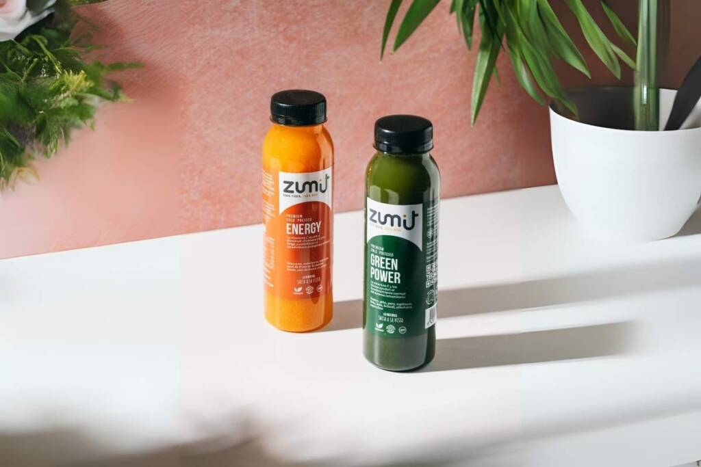 Sumos cold pressed Zumit Energia verde e energia sobre uma mesa branca